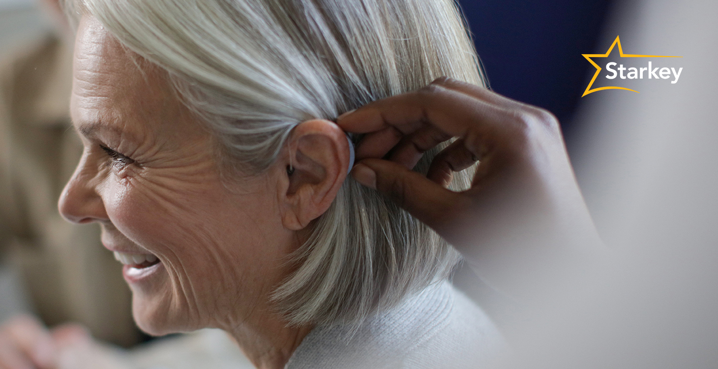 Senior woman being fitted for a behind-the-ear hearing aid by a hearing care professional